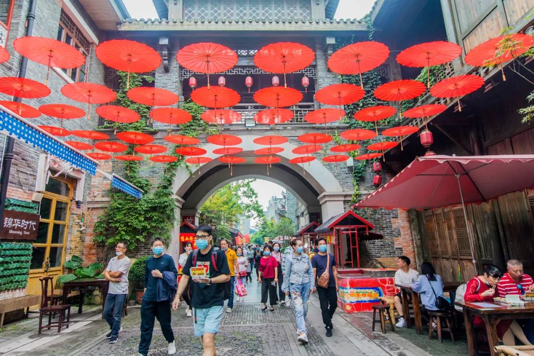 10月2日,武漢園博園漢口裡,遊客們穿過紅傘裝飾的街道遊玩.